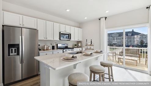 white kitchen with white kitchen island and stainless steel appliances