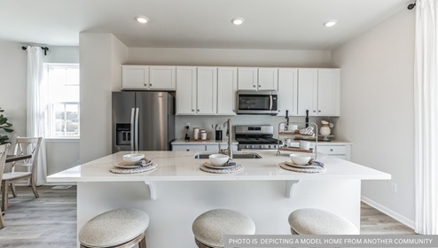 white kitchen with white kitchen island and stainless steel appliances