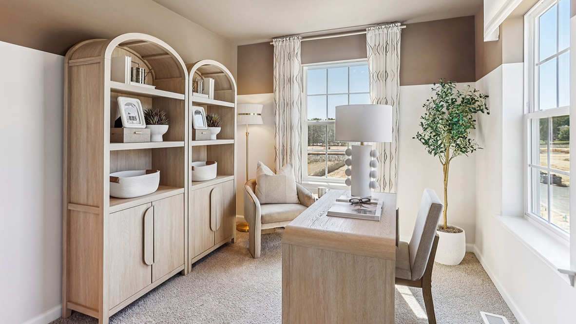 spacious office with large windows and light wood furniture