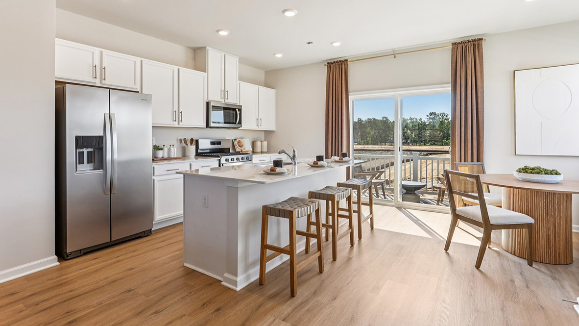 large kitchen island with seating and round table to the side for additional seating options