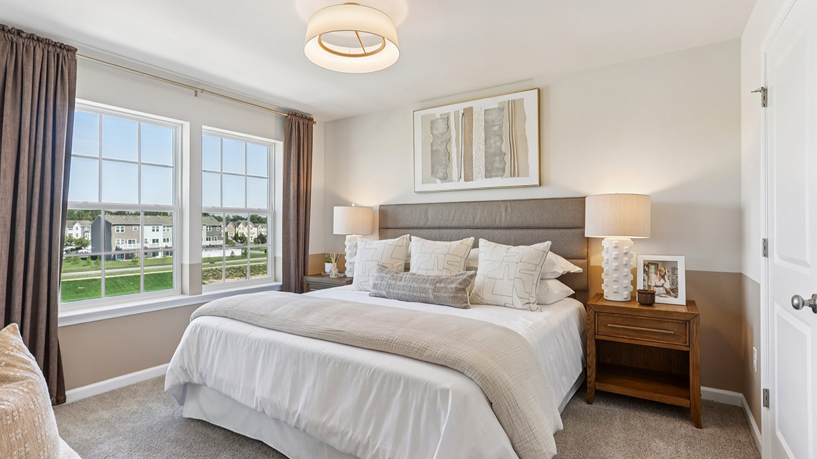 primary bedroom with neutral tones and large windows