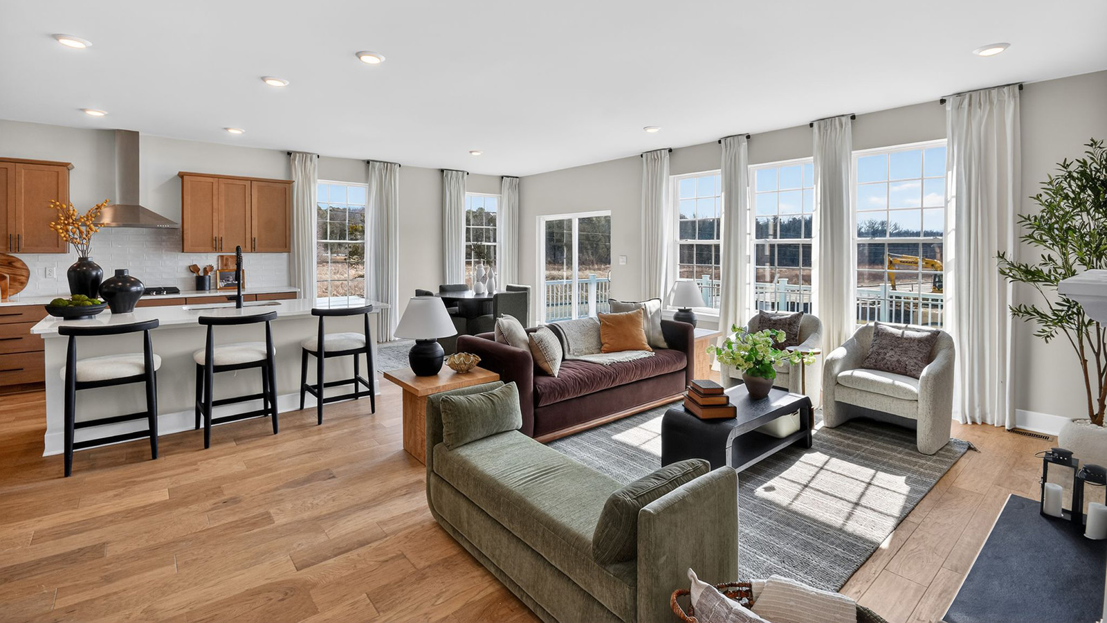 open concept living room with modern design and spacious kitchen behind
