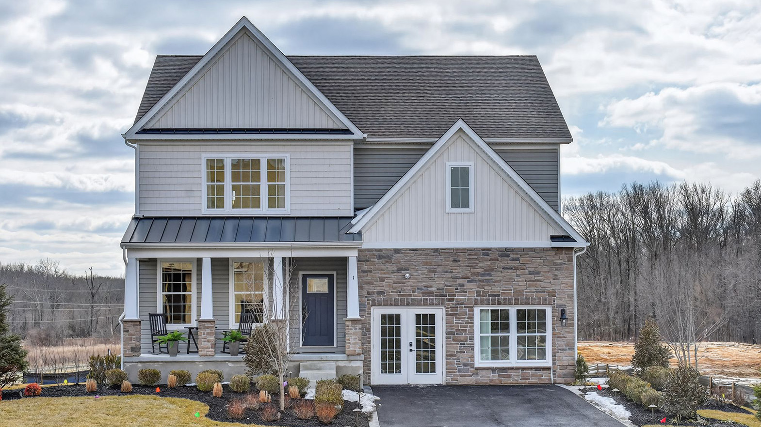 spacious exterior of a hampshire model showing neutral cool toned stone and siding