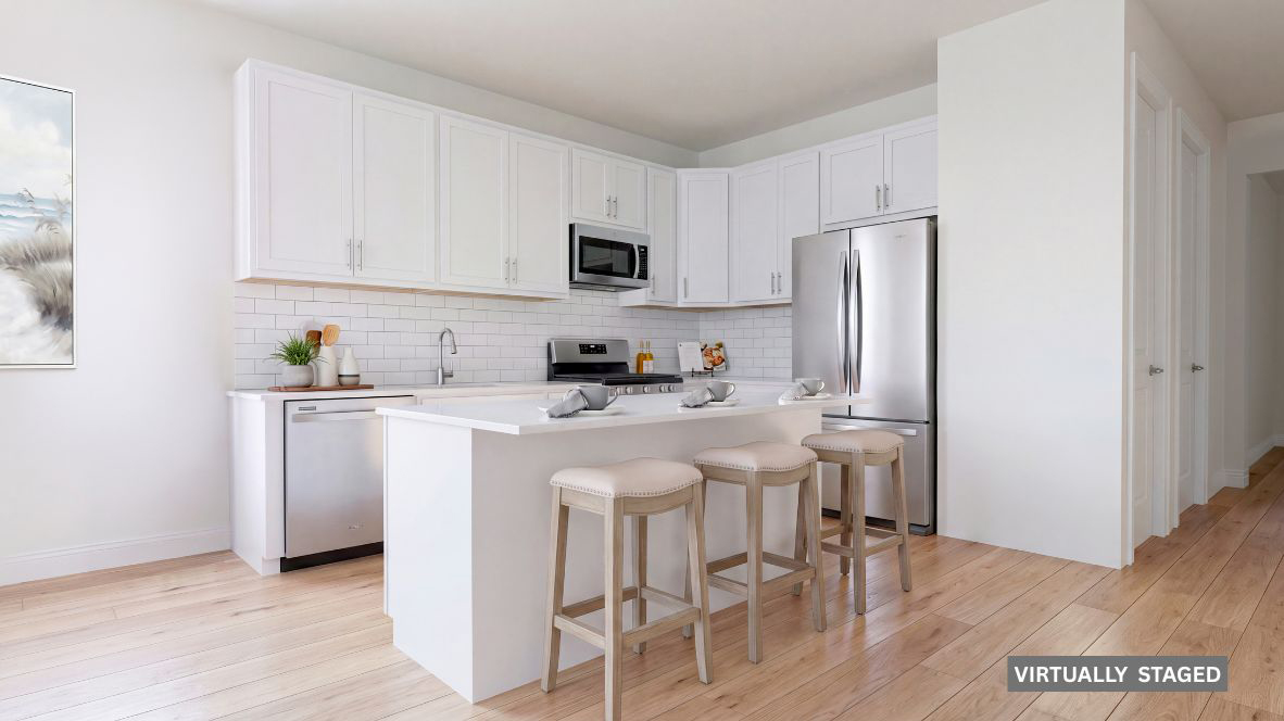 spacious kitchen with large quartz island, white cabinetry and stainless steel appliances