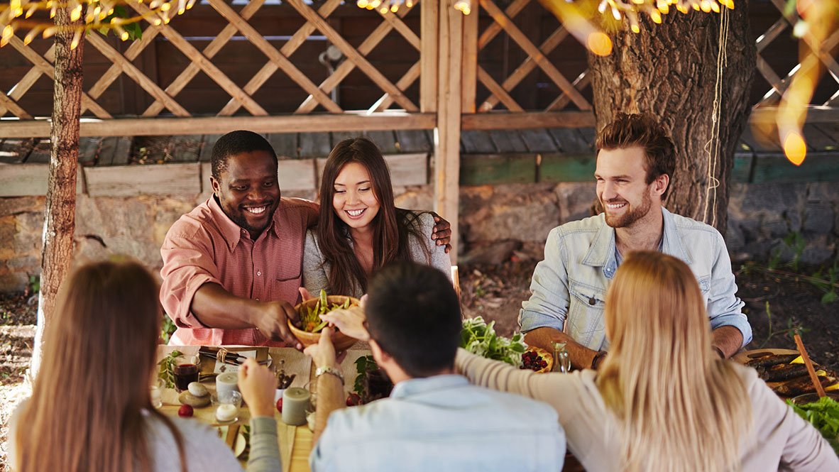 lifestyle photo of friends outside at dinner