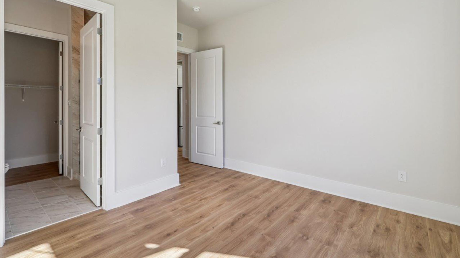 bedroom with hardwood and large windows