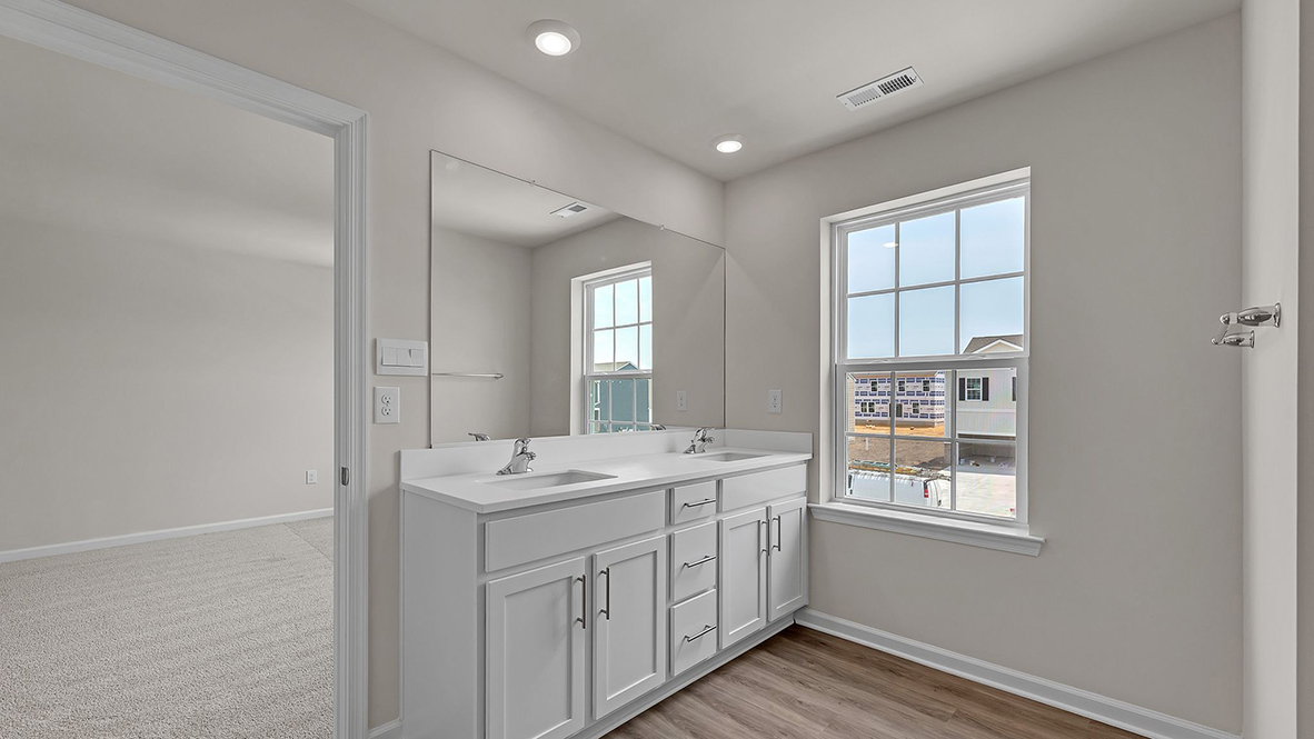 primary bathroom with double vanity sinks and glass shower