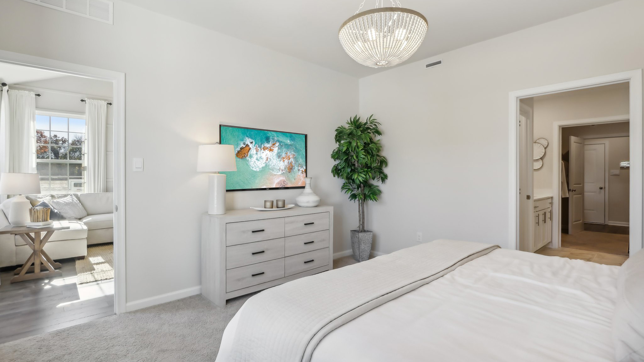 spacious primary suite on the first floor with en suite bath, walk in closet, and access to the laundry room