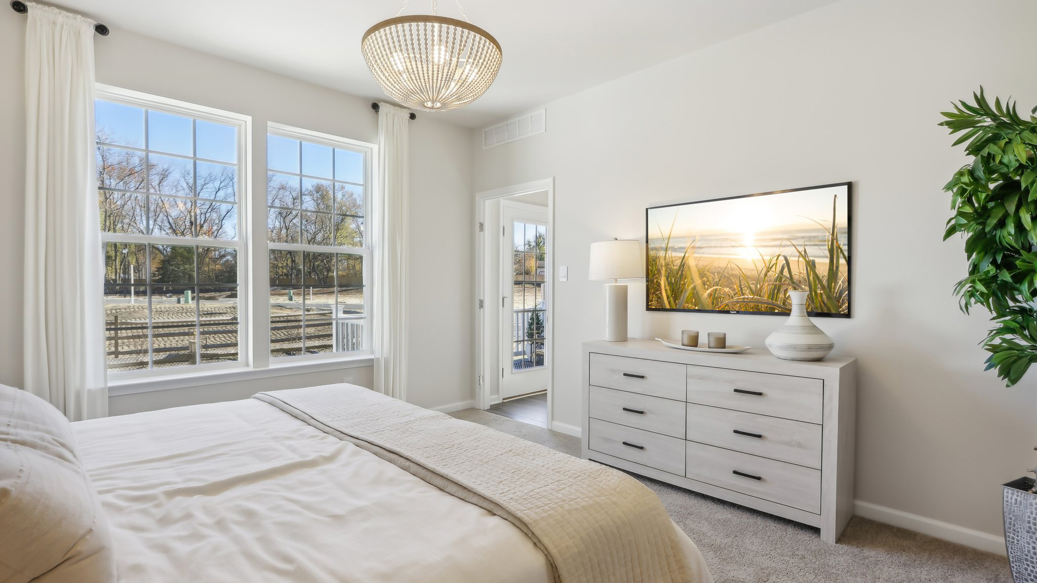 spacious primary suite on the first floor with en suite bath, walk in closet, and access to the laundry room