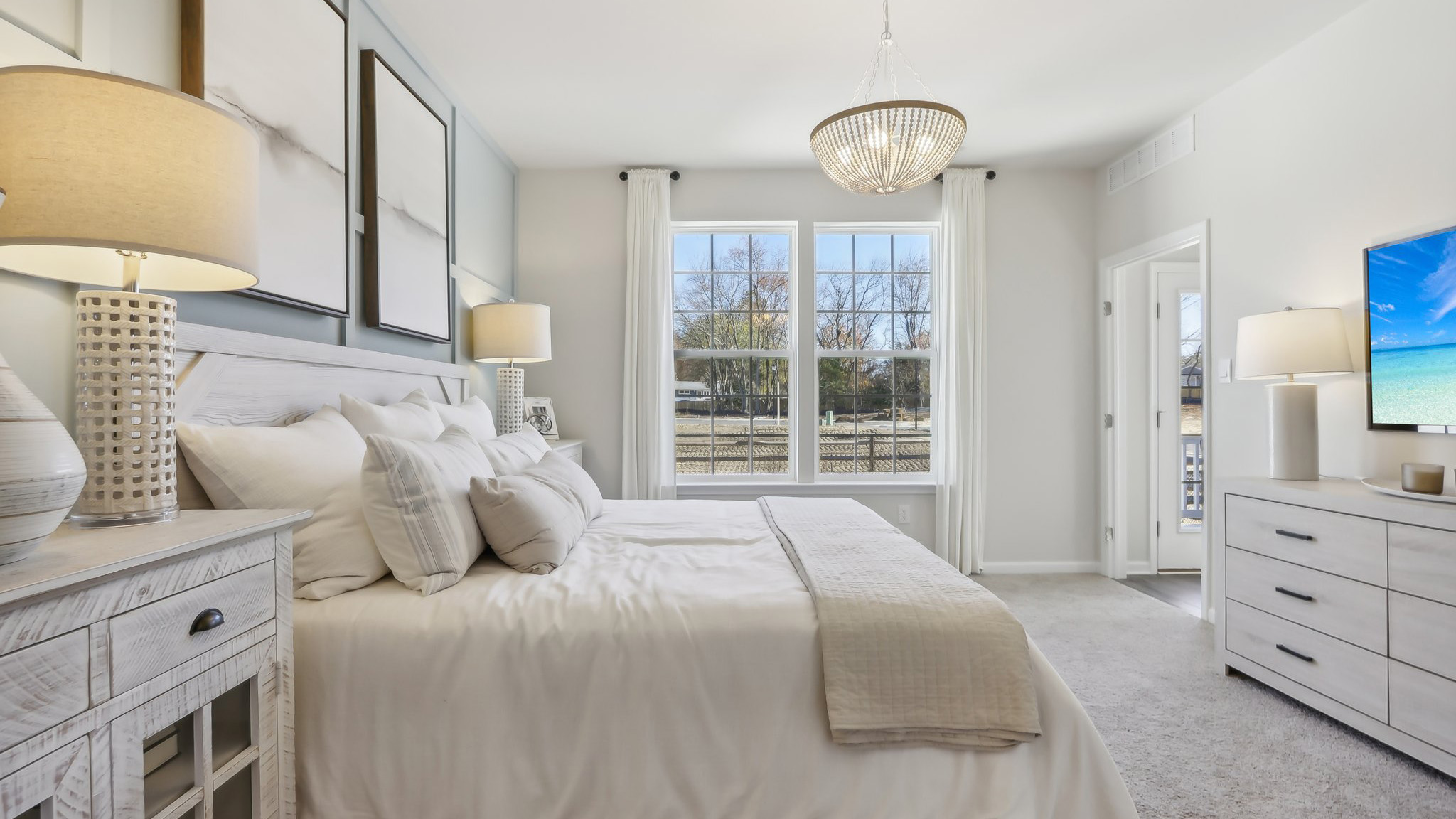 spacious primary suite on the first floor with en suite bath, walk in closet, and access to the laundry room