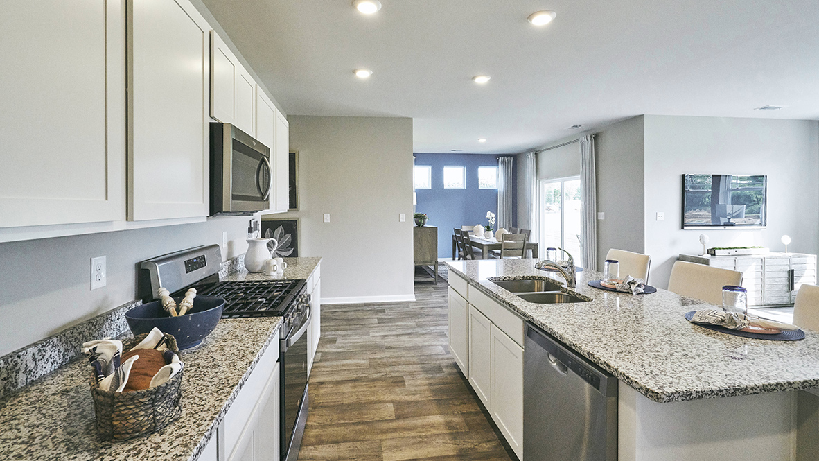 Featuring plank flooring, the kitchen is open to the dining room.