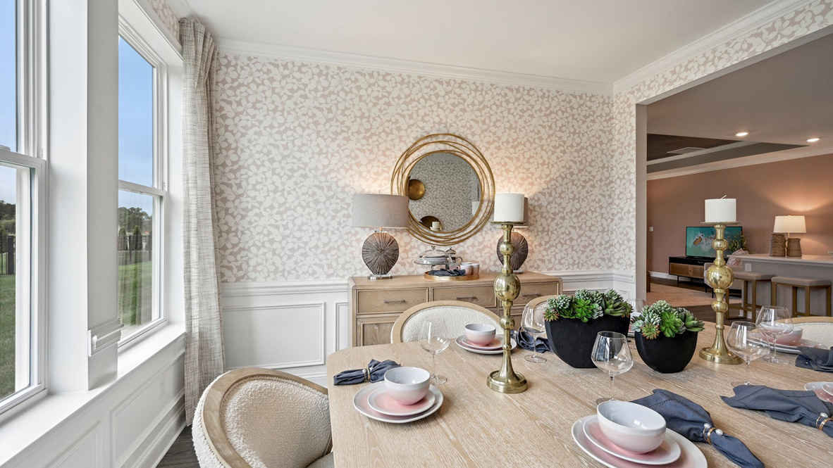 The dining room has large windows and wainscotting to dress the walls.