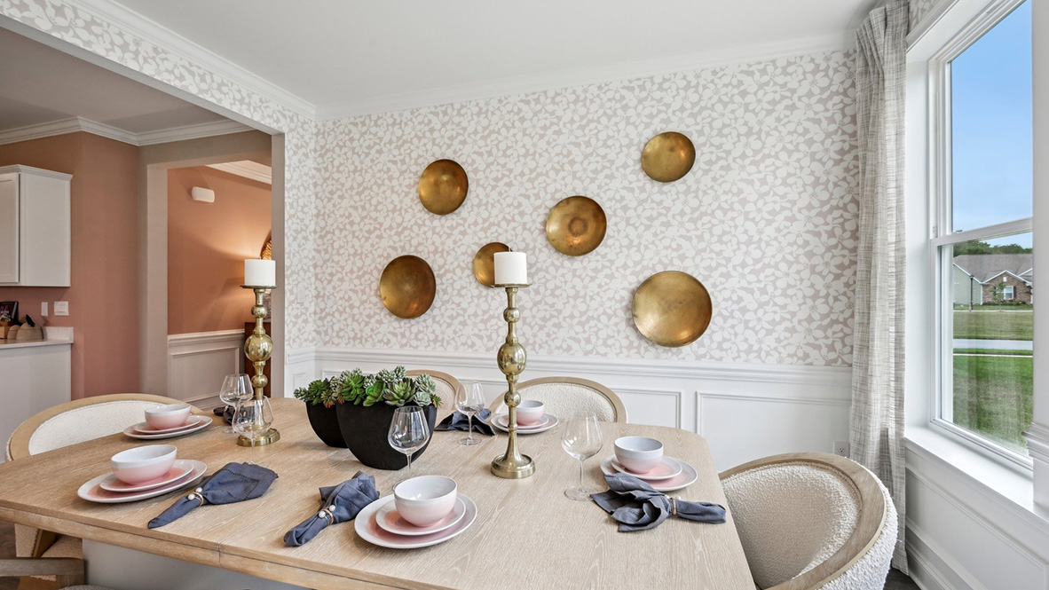 The dining room has large windows and wainscotting to dress the walls.