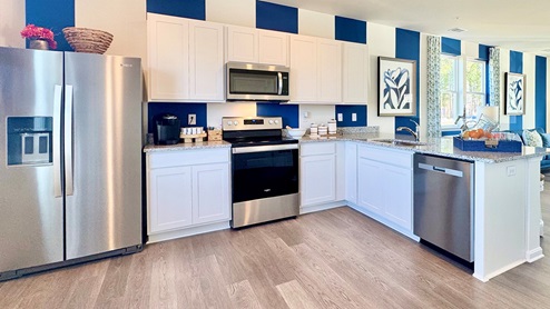The kitchen includes stainless steel appliances.