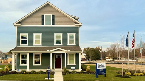 Simpsons Crossing Verona model on a corner homesite with blue siding and tan accents.