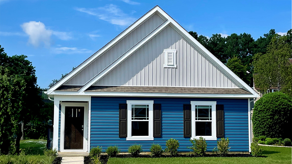 A Camberly ranch home with blue siding and black shutters.