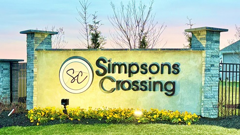 A photo at dusk of the Simpsons Crossing entrance monument.