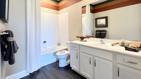 The second guest bathroom includes a vanity, toilet, and shower tub.