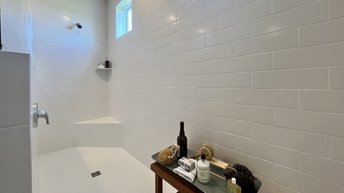 The walk-in shower has two windows along the ceiling for natural light.