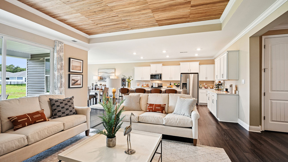 The open-concept great room with a tray ceiling leads you to the gourmet kitchen.