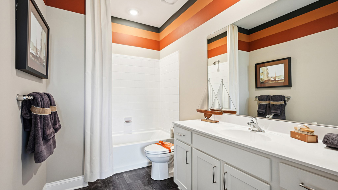The second guest bathroom includes a vanity, toilet, and shower tub.