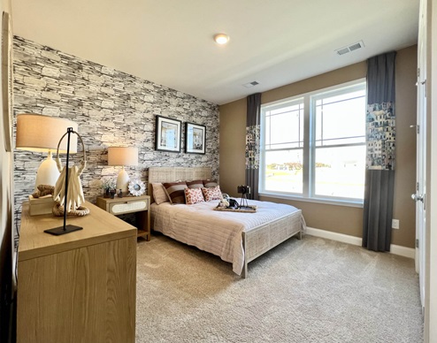 Primary bedroom with large windows.