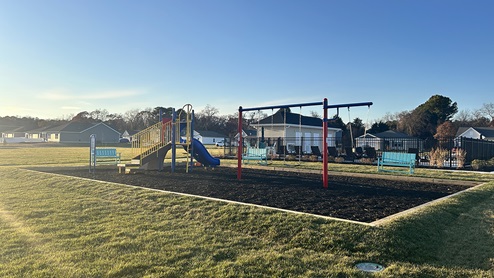 The Plover Point community playground with swings, slide, and benches.
