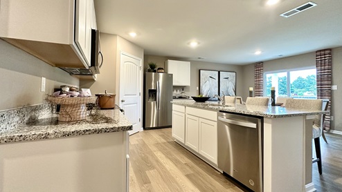 The kitchen includes stainless steel appliances.