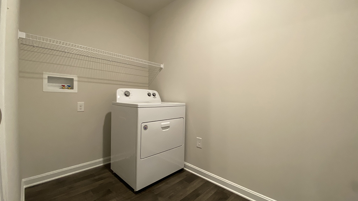 The laundry room is complete with a washer and dryer.
