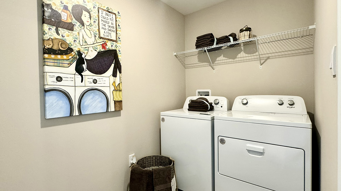 The laundry room is complete with a washer and dryer and located near the entrance to the two-car garage.