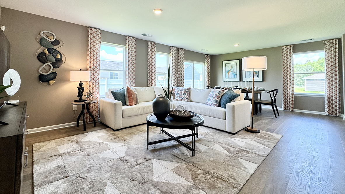 The expansive great room, with an abundance of natural light, flows seamlessly into the dining area.