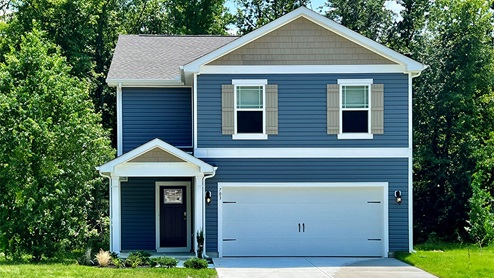 A Pine model home with blue siding and tan shutters.