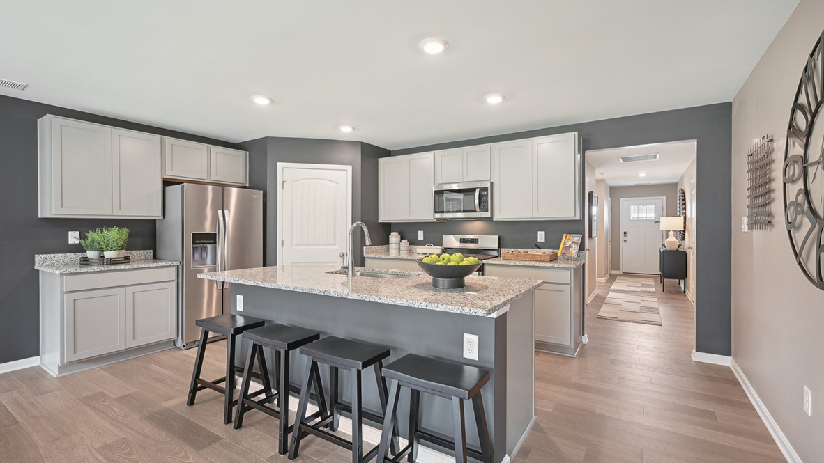 The open-concept kitchen has bright kitchen cabinets.