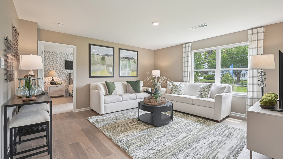 The cozy living area has a double window and laminate plank flooring.