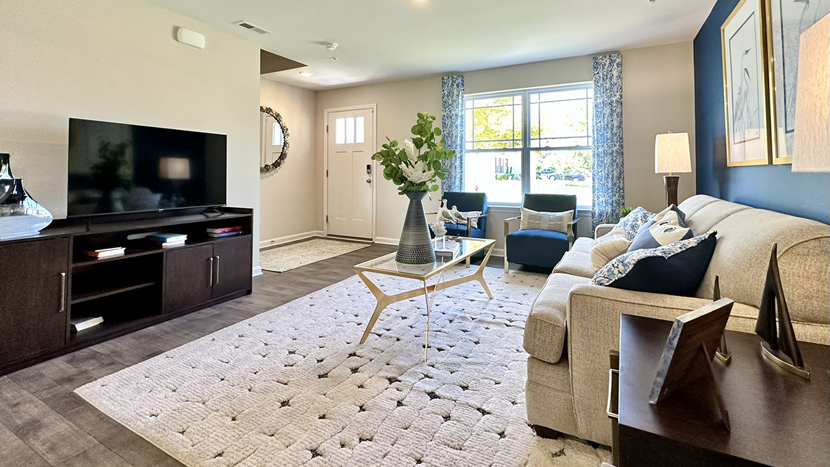 Open-concept living room with large front windows.
