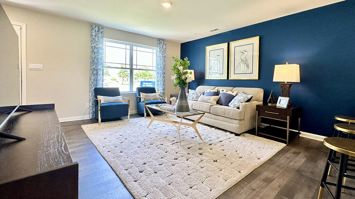Open-concept living room with large front windows.