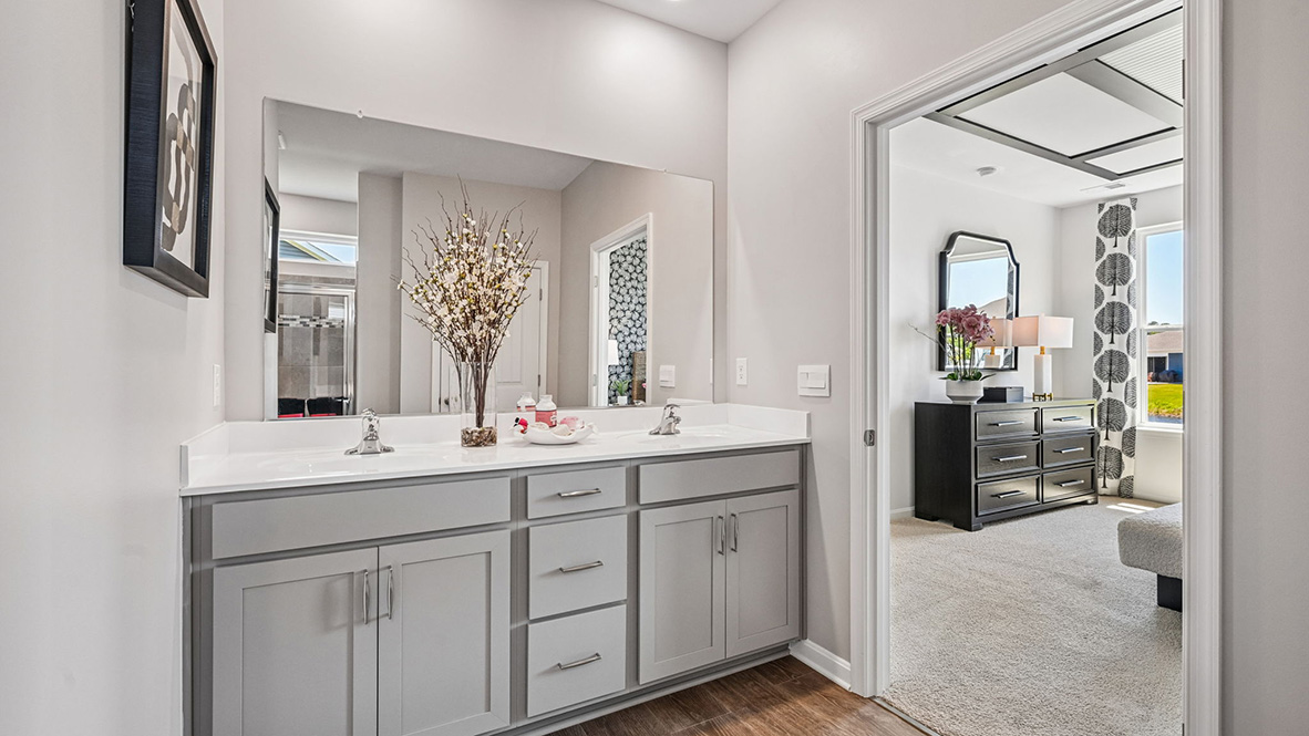 The spacious bathroom with a luxury shower has a double-bowl vanity.