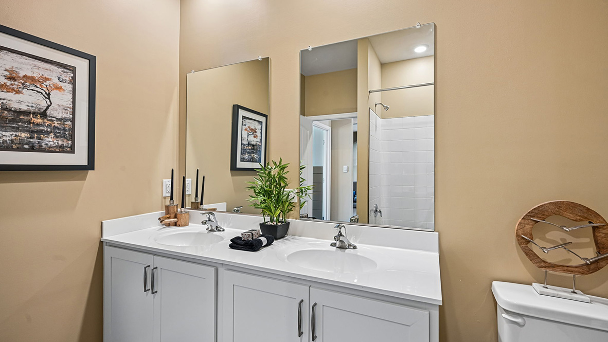 A shared guest bathroom has a double-bowl vanity.