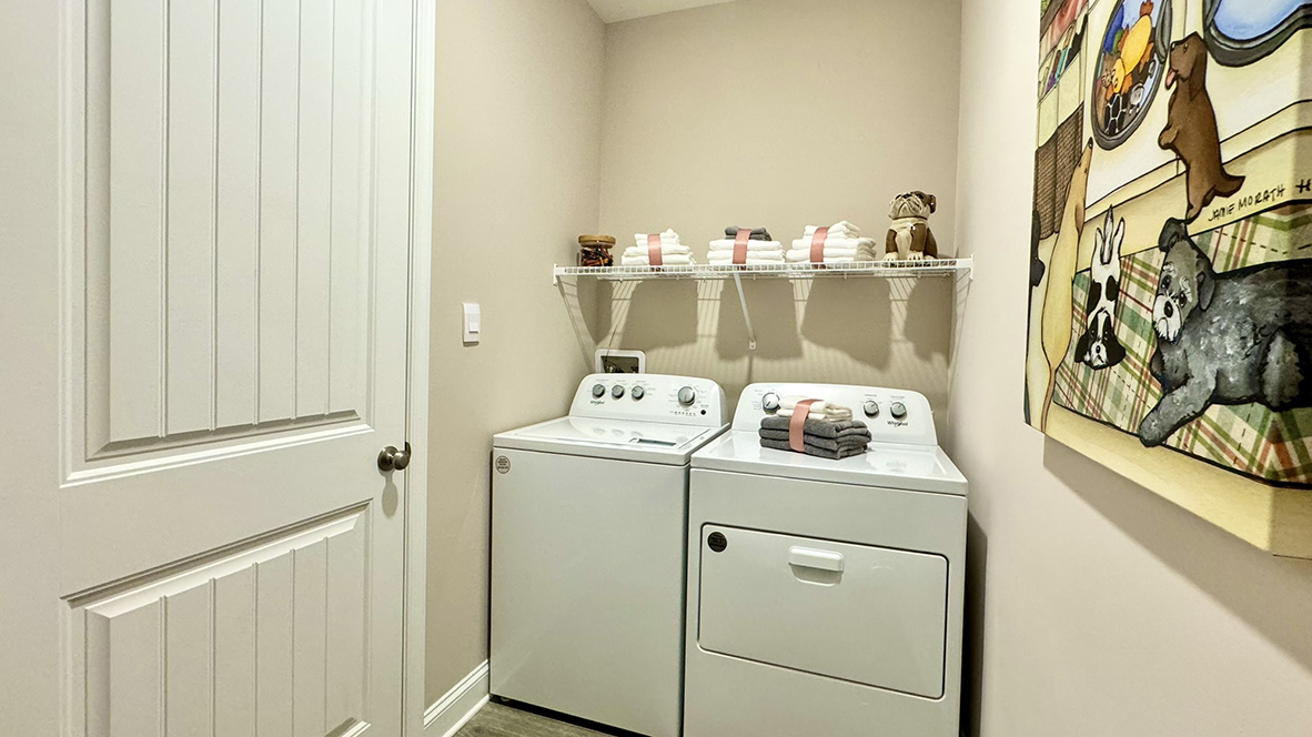 The large laundry room, tucked between the kitchen pantry and the three-car garage, also features a coat closet.