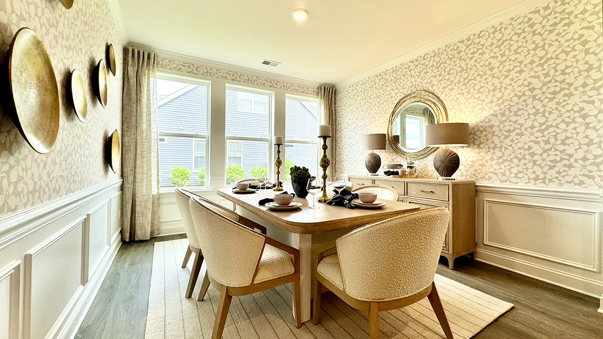 Dining room with large windows and wainscotting.