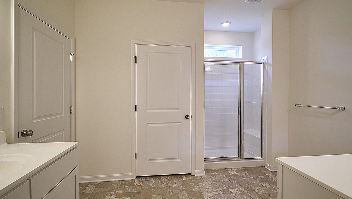 The owner’s suite with a private bathroom and a walk-in closet is a retreat in the back of the home.