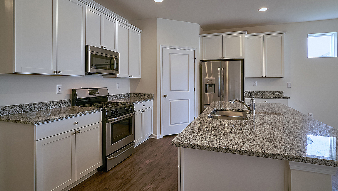 The open kitchen boasts a large island with quartz countertops.
