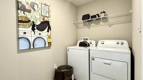 The laundry room is located near the entrance to the two-car garage.