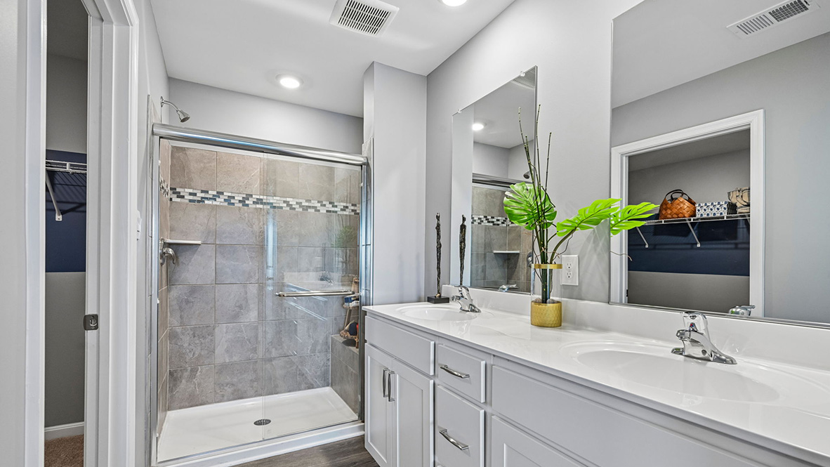 The modern primary bathroom has a double vanity and generously sized shower.