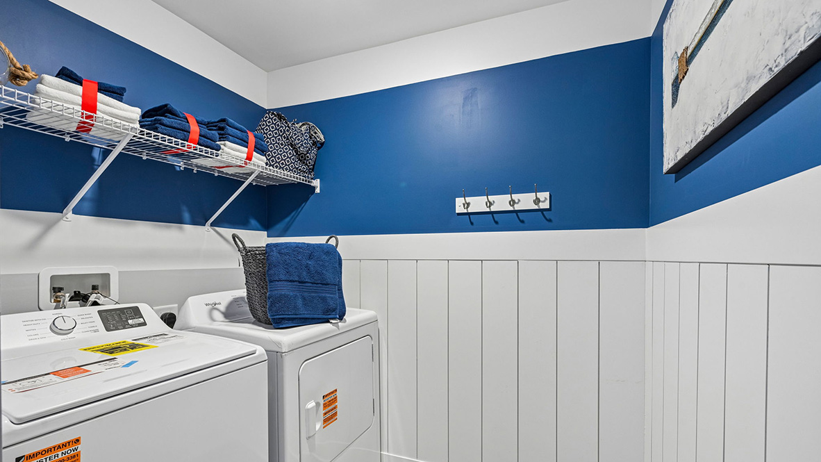 Upstairs, there is a functional laundry room and a large hallway linen closet.