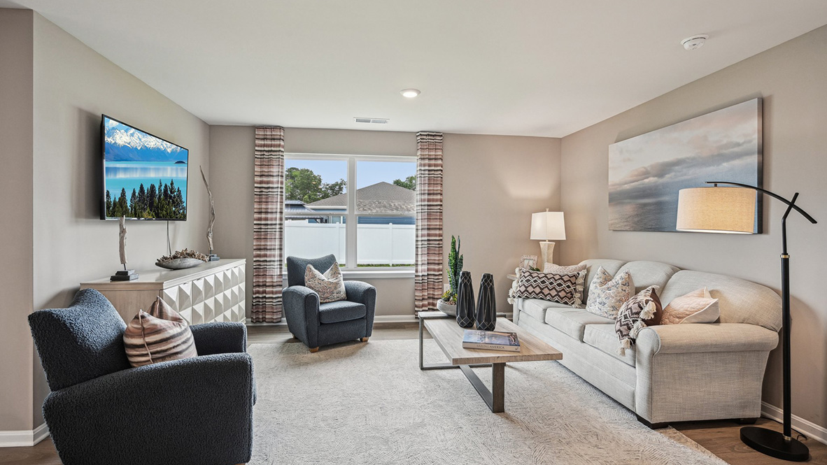The cozy living area has a double window and laminate plank flooring.