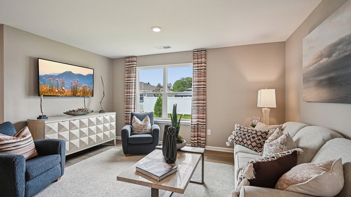 The cozy living area has a double window and laminate plank flooring.