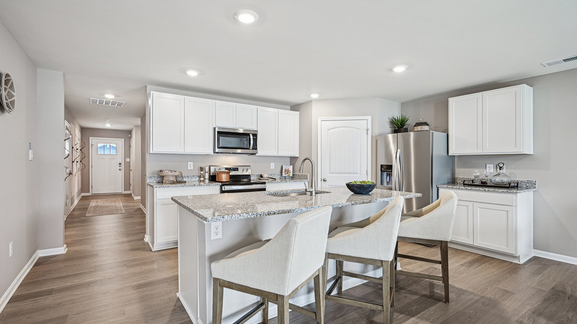 The open-concept kitchen has bright kitchen cabinets.