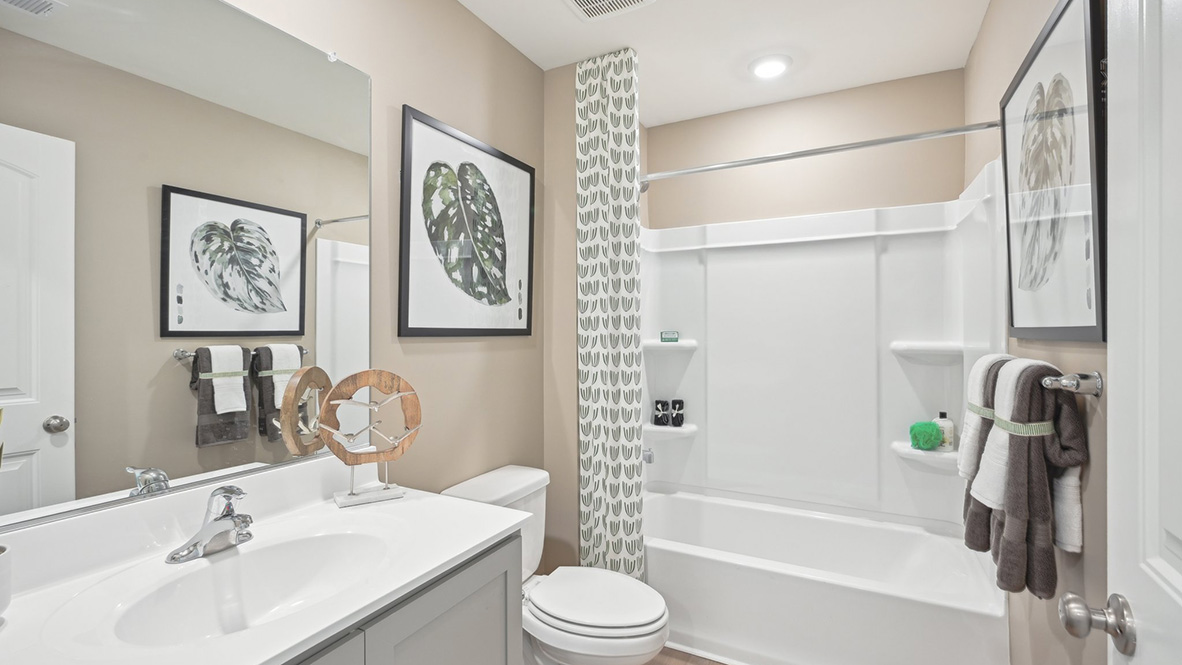 The guest bathroom includes a vanity, toilet, and shower tub.