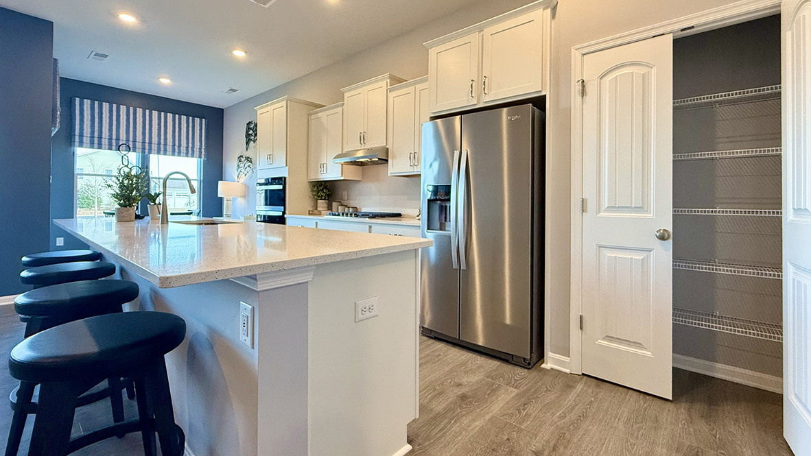 The open floorplan features a well-designed kitchen complete with stainless steel appliances.